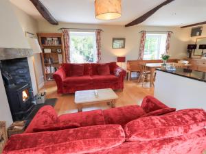 a living room with red furniture and a fireplace at Mell View Cottage in Watermillock +31 photos