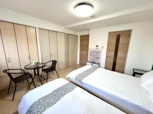 a bedroom with a bed and a table and chairs at 关西机场直达 i Home Osaka URBAN NOOK 舒适双床房 天下茶屋站步行3分钟 in Osaka
