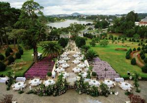 an aerial view of a garden with white tables and chairs at Dalat Palace Heritage Hotel in Da Lat