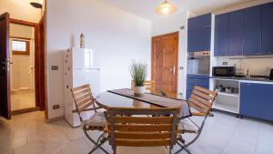 a kitchen with a table and chairs and a refrigerator at Marina Bay - Castelsardo in Castelsardo