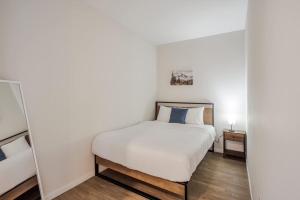 a small bedroom with a bed and a mirror at CozySuites Sky Central #20 in Cincinnati