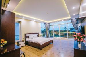 a bedroom with a bed and a large window at Villa Sao Biển 96 FLC Sầm Sơn in Sầm Sơn +9 photos