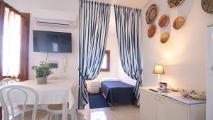 a room with a table and a bed and curtains at Marina Bay - Castelsardo in Castelsardo +55 photos