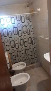 a bathroom with a toilet and a shower curtain at Daiana Carlos temporarios in Estación Guadalupe