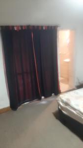 a bedroom with a window with a red curtain at Daiana Carlos temporarios in Estación Guadalupe +2 photos