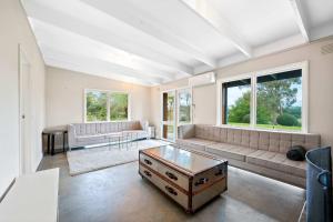a living room with a couch and a table at Yarra Valley 2BR Lux Vineyard Retreat in Dixons Creek