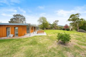 a house with a large yard with a bench at Yarra Valley 2BR Lux Vineyard Retreat in Dixons Creek +8 photos