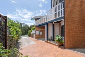 a brick walkway next to a brick building at Spooky Beach Lodge - Oceanstays in Yamba