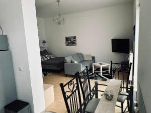 a living room with a couch and a table and chairs at DG City-Apartment in Spremberg