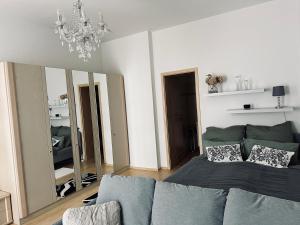 a living room with a bed and a large mirror at DG City-Apartment in Spremberg +4 photos