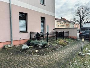 a garden in front of a house with a fence at DG City-Apartment in Spremberg