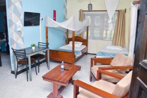 una habitación con un dormitorio con una cama y una mesa en One Bedroom with 3 beds can sleep 4, en Mombasa
