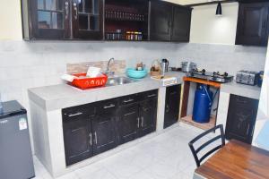 una cocina con armarios negros, fregadero y mesa en One Bedroom with 3 beds can sleep 4, en Mombasa