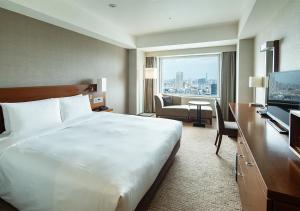 a hotel room with a large bed and a television at Odakyu Hotel Century Southern Tower in Tokyo