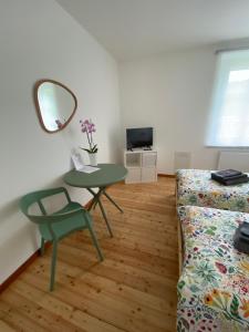 a living room with a table and a couch and a mirror at Affittacamere Torrione in Venzone