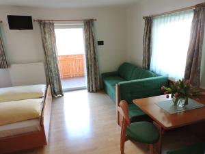 安泰塞爾瓦·迪·梅佐的住宿－庫萊霍夫公寓，客厅配有绿色沙发和桌子