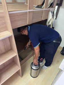a man is holding a pot in a drawer at Panda Lodge Home Stay in Bangkok