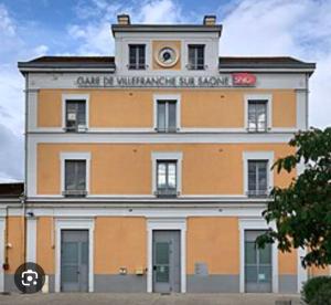 a orange and white building with a sign on it at Maison La Praline in Arnas