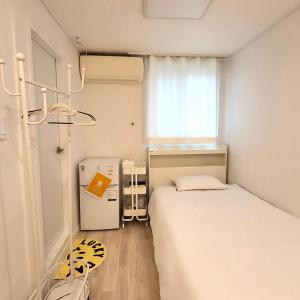 a small room with a bed and a refrigerator at Humming stay in Seoul