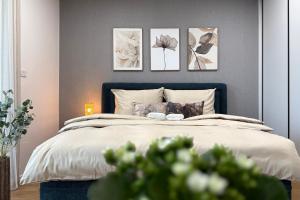 a bedroom with a bed with four pictures on the wall at Apartmán Klement in Znojmo