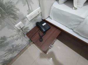 a telephone on a wooden table in a bedroom at Townhouse Cineplanet Kompally in Hyderabad