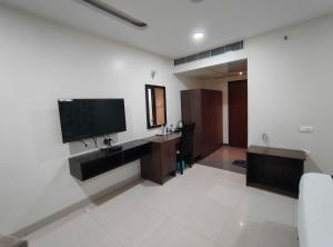 a living room with a tv on a wall at Townhouse Cineplanet Kompally in Hyderabad
