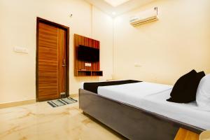 a bedroom with a bed and a television in it at Hotel O Sunraj Stay in Mohali
