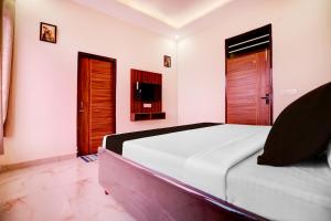 a bedroom with a large white bed and wooden doors at Hotel O Sunraj Stay in Mohali
