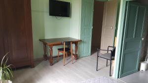a room with a table and two chairs and a television at Pradines in Saint-Pons-de-Mauchiens