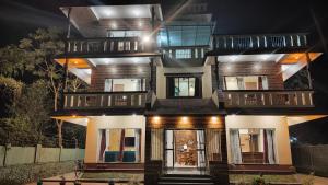 a tall house with a lit up facade at night at Resort Morning Glory in Lataguri
