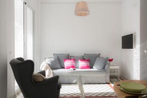 sala de estar con sofá y almohadas rosas en Apartments Carmen III, en Valencia