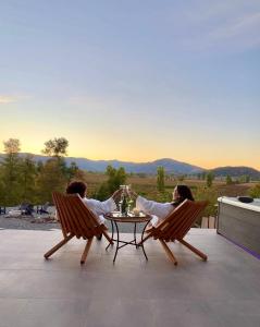 two people sitting at a table on a patio at TyM House in Las Pataguas