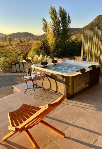 a hot tub on a patio with a chair and a table at TyM House in Las Pataguas