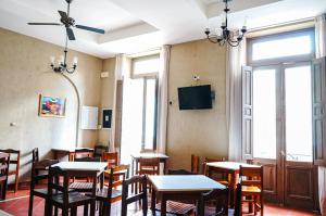 a dining room with tables and chairs and a tv at Hotel de la Linda in Salta