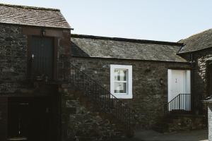 a brick building with a staircase and a white door at Highside Farm in Bassenthwaite +54 photos