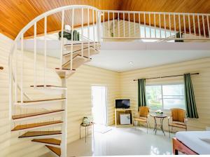eine Wendeltreppe in einem Zimmer mit einem Wohnzimmer in der Unterkunft Rockwood house Resort and Thai massage ร็อควู้ด เฮาส์ รีสอร์ท แอนด์ ทรงวาดนวดแผนไทยเพื่อสุขภาพ และสปา in Pak Chong
