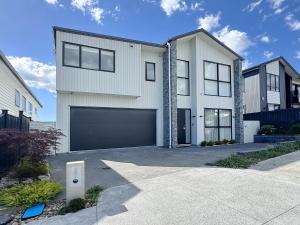 a large white house with a garage at Spacious 7 BRs 4 BHs house on Longhorn, Flat Bush in Auckland