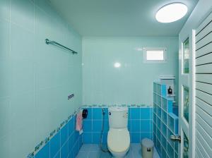 ein Bad mit einem WC und blauen Fliesen in der Unterkunft Rockwood house Resort and Thai massage ร็อควู้ด เฮาส์ รีสอร์ท แอนด์ ทรงวาดนวดแผนไทยเพื่อสุขภาพ และสปา in Pak Chong
