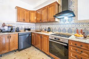 a kitchen with wooden cabinets and a stove top oven at Sunrise Campello - Azahar Suite in El Campello