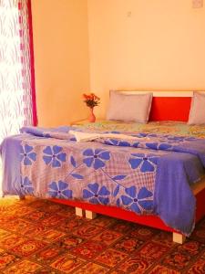 a bedroom with a blue and white comforter on a bed at Golden Palace Royal in Leh