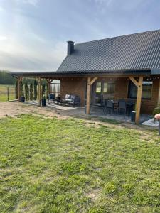 a log cabin with a table and chairs in a field at Domek w Budzie Ruskiej in Buda Ruska