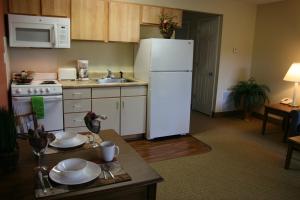 a kitchen with a white refrigerator and a sink at Affordable Suites of America Fredericksburg in Fredericksburg