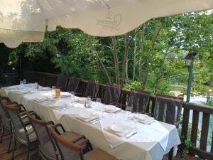 a long table with white table cloths and chairs at Eko Kamp odmorište Brig in Duga Resa +14 photos