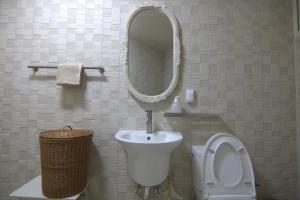 Un baño con lavabo, inodoro y espejo. en OhHey, en Busan 14 fotos más