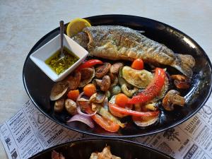 a plate of food with fish and vegetables on a table at Eko Kamp odmorište Brig in Duga Resa