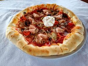 a pizza sitting on a plate on a table at Eko Kamp odmorište Brig in Duga Resa