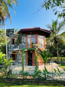 a house with palm trees in front of it at Romantic Jungle Hideaway in Tangalle