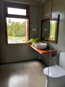 a bathroom with a sink and a window at Romantic Jungle Hideaway in Tangalle