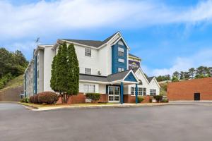 a blue and white building with a parking lot at Microtel Inn & Suites by Wyndham Norcross in Norcross