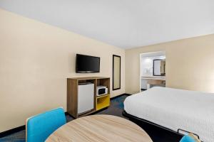 a hotel room with a bed and a tv at Days Inn by Wyndham Tucson Airport in Tucson +21 photos